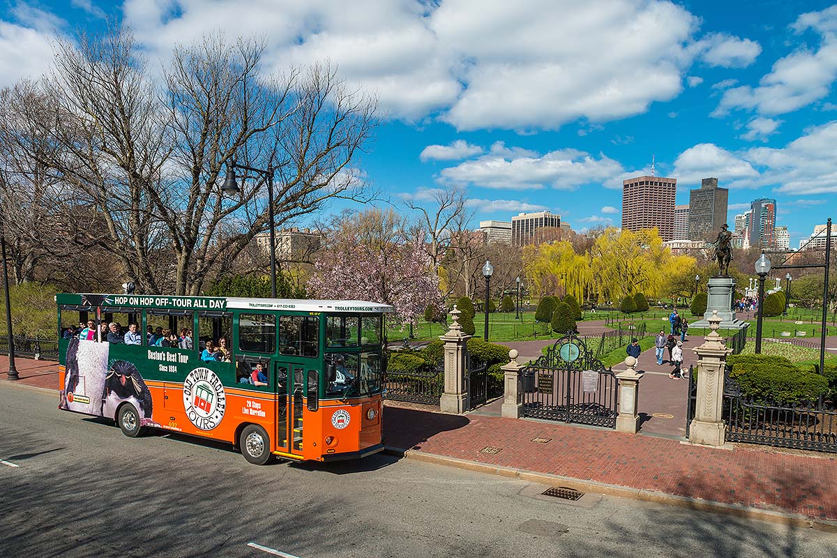 Boston trolley driving past George Washington statue