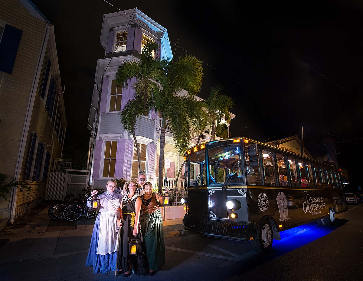 Key West ghost hosts and trolley in front of house at night