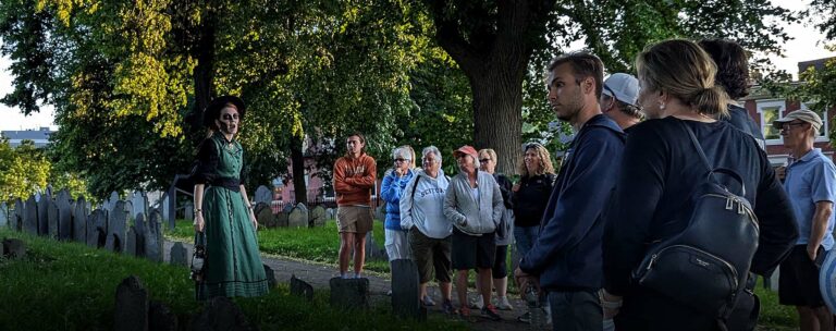 Ghosts & Gravestones Nightwalk tour guide and guests at burying ground